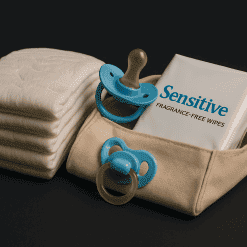 Soft baby wipes, pacifiers, and pacifier clips arranged on a dark background, highlighting baby care essentials for new parents.