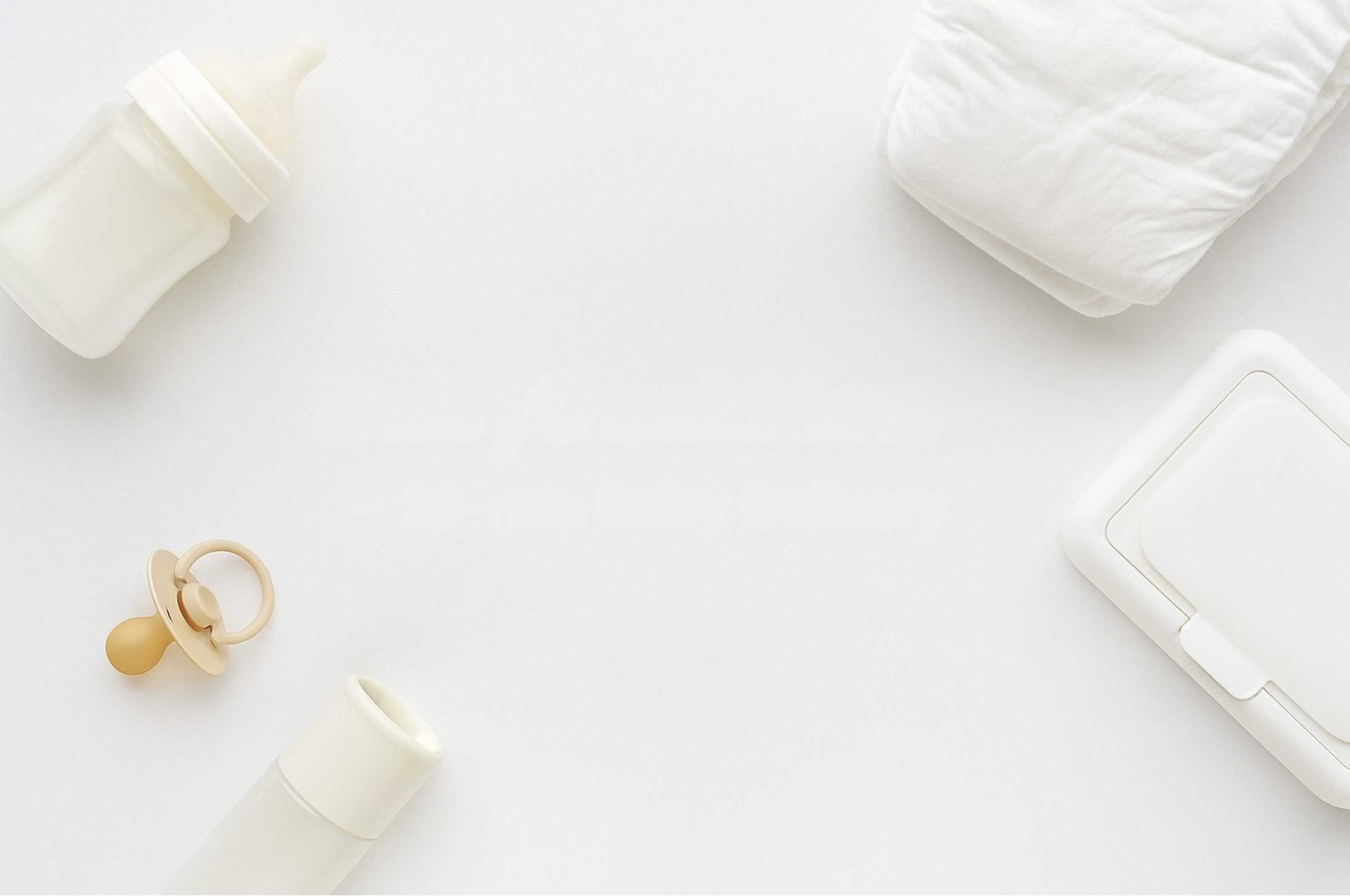 Gentle white baby essentials including a pacifier, bottles, diapers, and a diaper rash cream on a clean, white background, representing convenient baby product delivery services in Stamford.